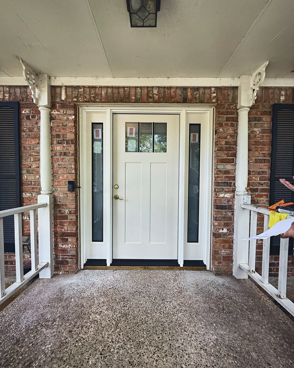 White Craftsman entry door with full-glass sidelights on a covered brick porch
