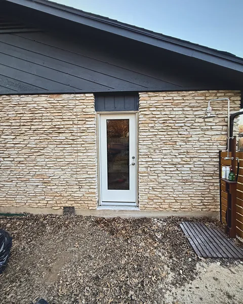 New full-glass door installed in a stone wall where a window used to be
