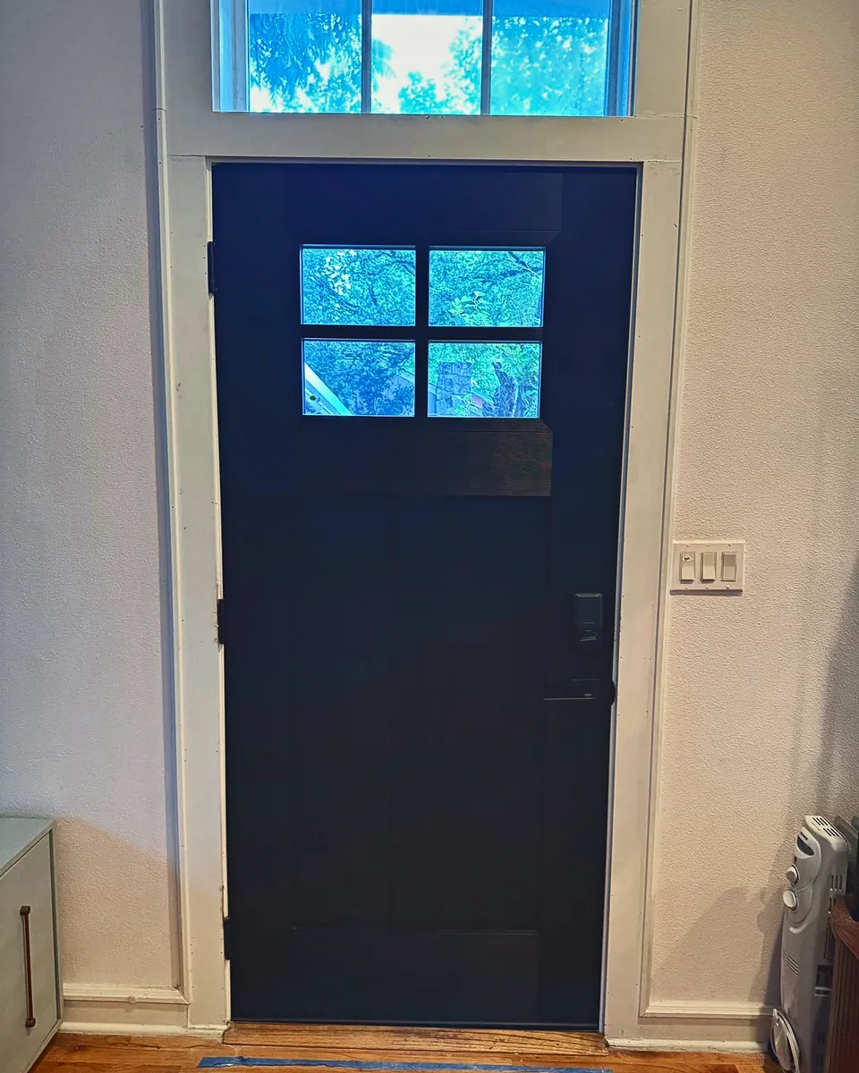 Black Craftsman entry door under a transom