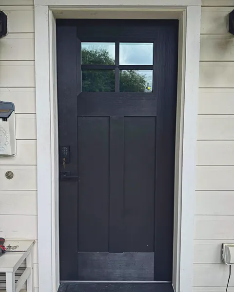 Black Craftsman entry door with three-lite glass and white trim
