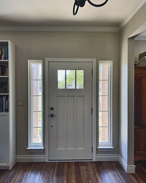 Interior view of a white Craftsman entry door with sidelights and new trim
