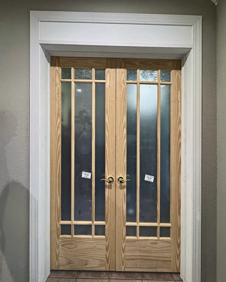 Pair of divided-light wood French doors installed in a new interior opening