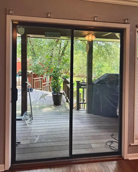 Dark-framed sliding glass door opening to a covered deck