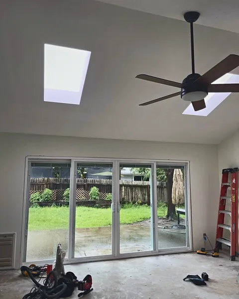 Three-panel sliding glass door set in a newly framed, widened opening during installation