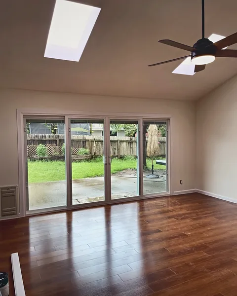 Sliding glass patio door in a bright vaulted room with skylight