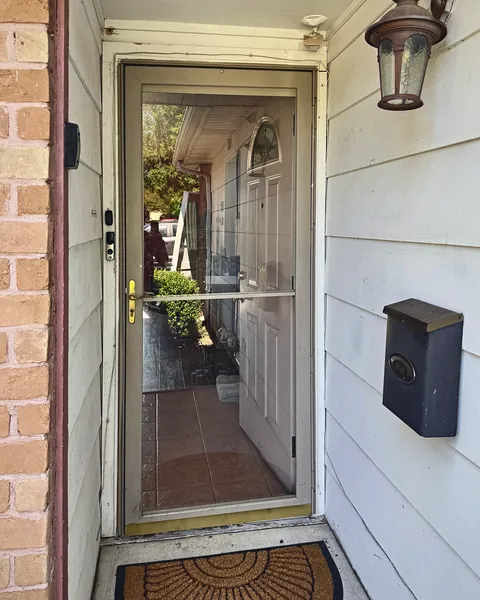 Full-view glass storm door installed over a front entry door