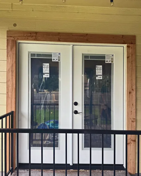 White full-glass French doors with cedar trim opening to a balcony
