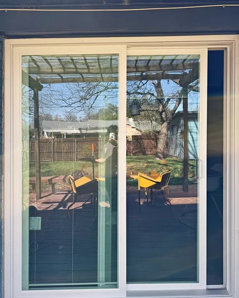 White vinyl sliding patio door opening to a pergola